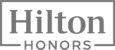 The image contains the logo for Hilton Honors, with "Hilton" in bold letters above "Honors" in a smaller font, both set within a rectangular border.